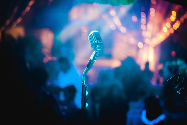 Silver bullet mic with blurred audience in the background 