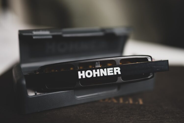 Black Hohner harmonica with case