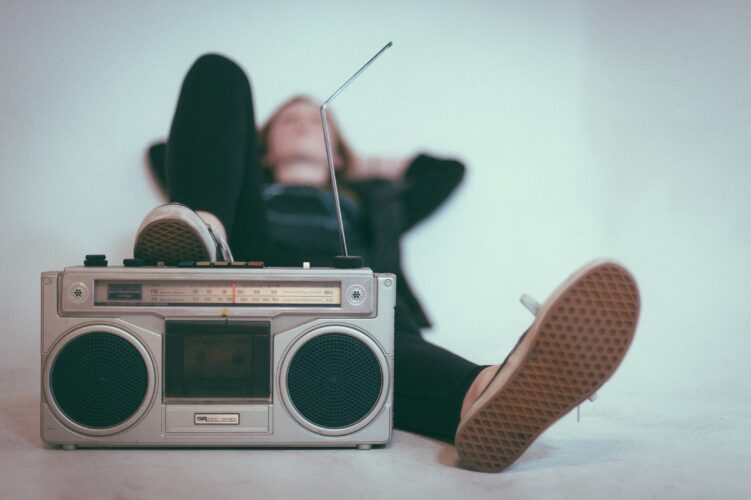 Man laying down with one foot up on silver stereo 