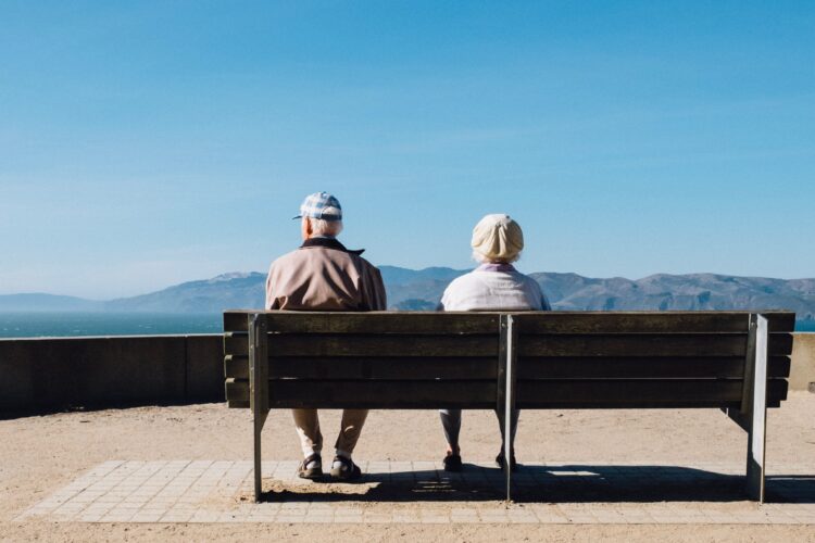 elderly couple sitting on bench