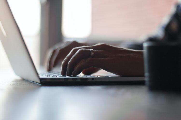 man typing on laptop